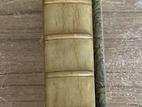 un vieux livre posé sur une table en bois, à côté d'un stylo