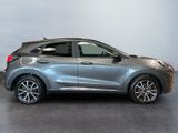 the silver car is parked in a room with a gray wall