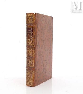 un vieux livre posé sur une table blanche à côté d'un mur blanc