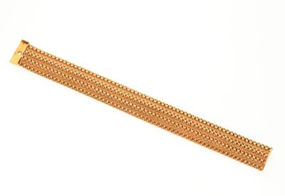gros plan d'un bracelet en or sur fond blanc