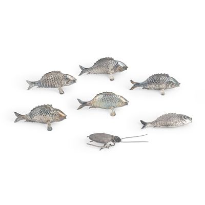 Des figurines de poissons argentés sont disposées en cercle sur une surface blanche