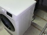 a washing machine sitting on the floor next to boxes