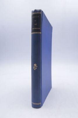an old blue book sitting on top of a table next to a white wall