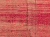 a close up of a red and pink rug with a cross on it