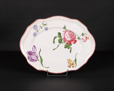 an image of a plate with flowers painted on it on a black surface