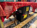 a table with a red table cloth on it and a black trash can underneath it