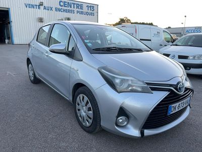 the silver toyota yaris is parked in front of a building