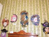 de nombreux masques accrochés au mur au-dessus d'une commode