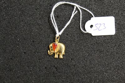 a small gold elephant with a red heart on it ' s back
