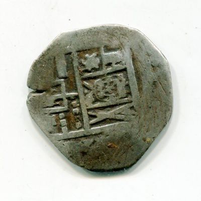 an old coin with a design on it on a white surface