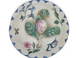 a plate with a flower on it on a white surface