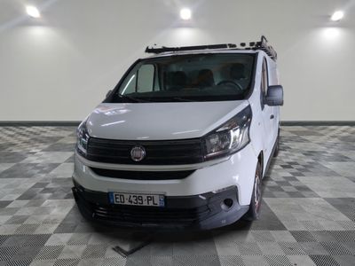 une camionnette blanche garée dans une pièce au sol en damier
