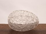 a glass bowl filled with white rocks on a wooden table