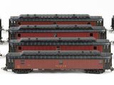 four red and black train cars sitting next to each other on a white surface