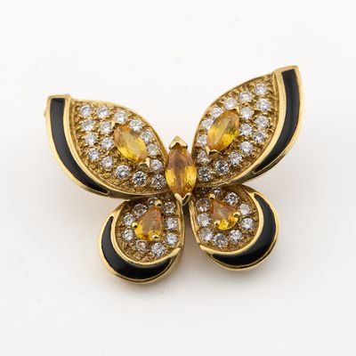 une photo d'une broche en forme de papillon jaune et noir, sertie de diamants