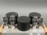 a close up of a silver and black amplifier on a wooden stand
