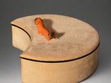 a small wooden box with a carrot on top of it