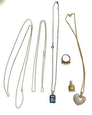 several necklaces and rings are arranged on a white surface
