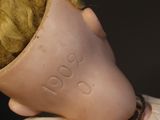 a close up of a doll with a chain around it ' s neck
