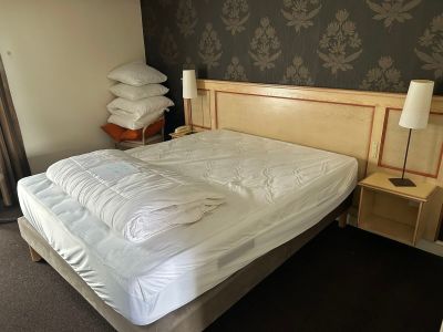 un lit sur lequel sont posés une couette blanche et des oreillers