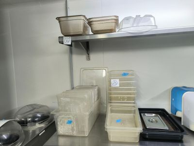 many containers and pans on the shelf in the kitchen