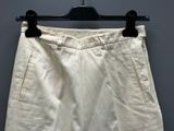 the white shorts are hanging on a hanger on the wall