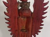 an old wooden statue of a bird with a crown on top of a blue cloth