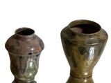 deux vases posés l'un à côté de l'autre sur une surface blanche