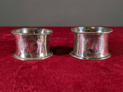 deux porte-serviettes en métal argenté posés sur une nappe rouge