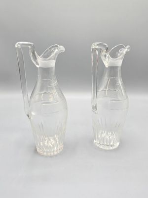une paire de vases en verre transparent posés sur une table blanche