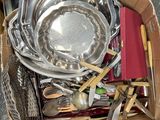 a cardboard box filled with silverware and utensils