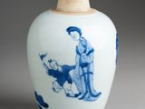 a blue and white vase with a woman and a dog on it