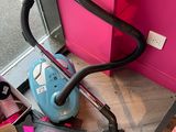 a vacuum that is sitting on the floor next to a pink wall