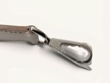 a silver metal object with a leather handle on a white surface