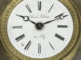 a gold clock with roman numerals on the face