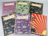 Cinq livres de styles et de couleurs variés sont alignés sur une table
