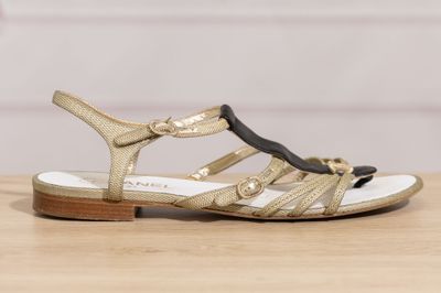 a close up of a pair of sandals on a wooden table