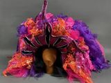 chapeau à plumes violet, orange et rose sur une tête de mannequin
