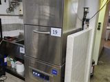 un grand réfrigérateur en acier inoxydable dans une cuisine dotée de nombreux plans de travail