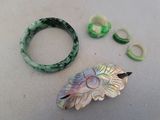 two pieces of jewelry sitting on a table next to each other