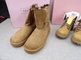 two pairs of women ' s ugg boots are on display in front of a pink box