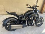 a picture of a black motorcycle parked in front of a building