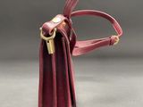 a red leather purse with a gold clasp and handle