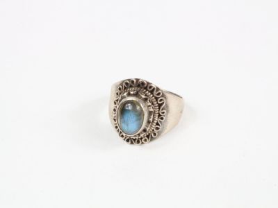 un gros plan d'une bague en argent sertie d'une pierre bleue