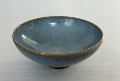 un bol bleu posé sur une table blanche