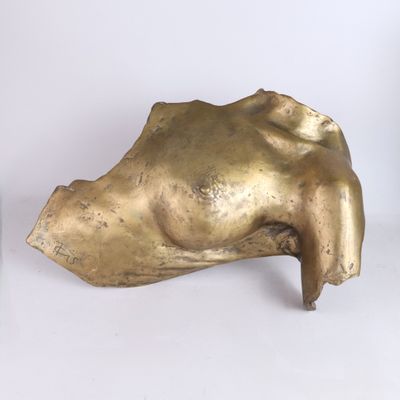 a gold sculpture of a woman ' s head on a white surface