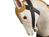 a wooden horse head with a harness on it ' s head