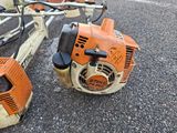 two chainsaws sitting next to each other on the ground