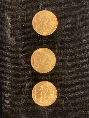 trois pièces d'or sur un tissu noir