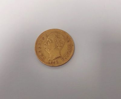 gros plan d'une pièce d'or sur une surface blanche